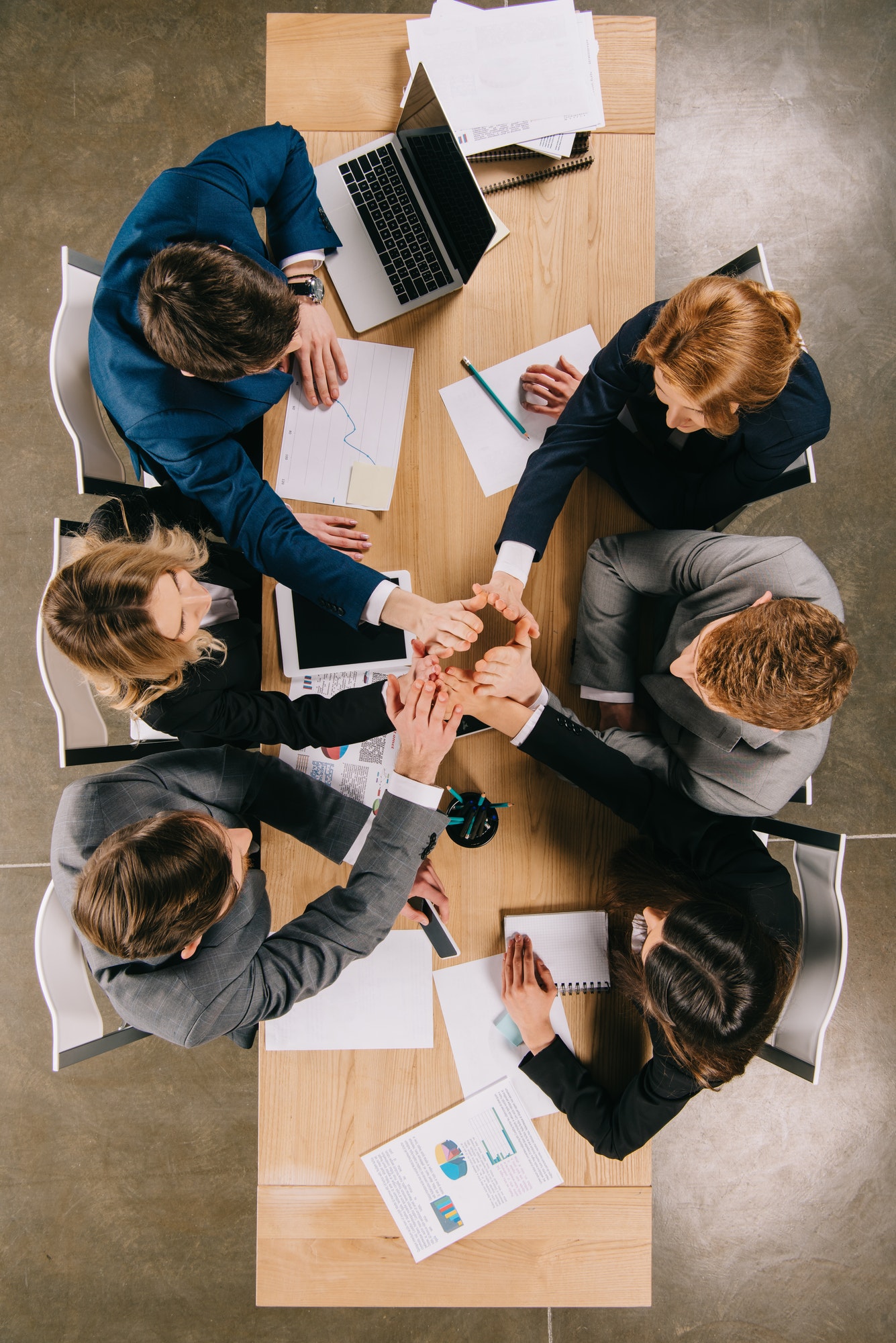 overhead view of business partners at table in office, businesspeople teamwork collaboration