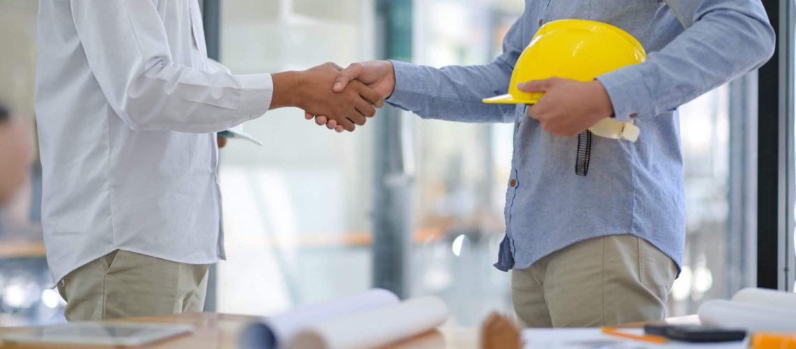 Architects and contractors shake hands to work.